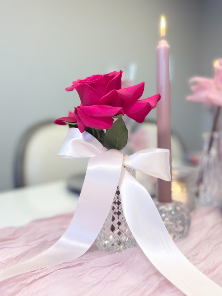 Bud vase with a single rose and long satin ribbon