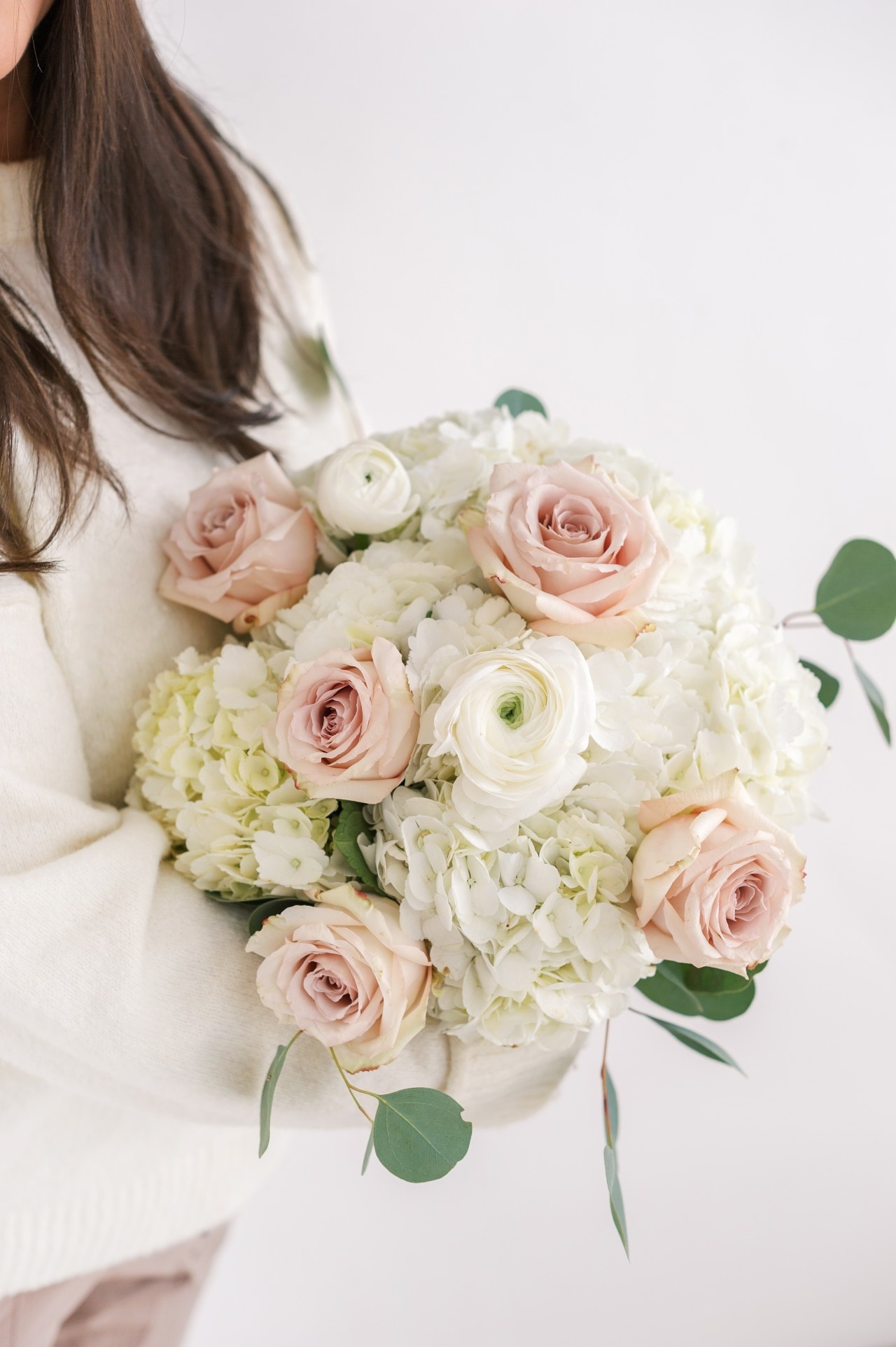 Ivory Luxe flower bouquet boasting fluffy white hydrangeas, gorgeous quicksand roses and showstopper ranunculus.