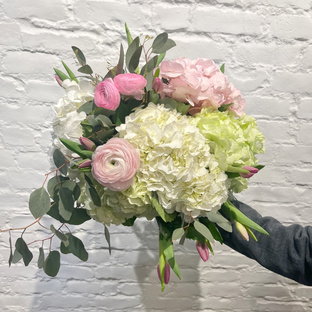 Fluffy hydrangeas, cheerful tulips and gorgeous ranunculus, accented with stunning silver dollar.