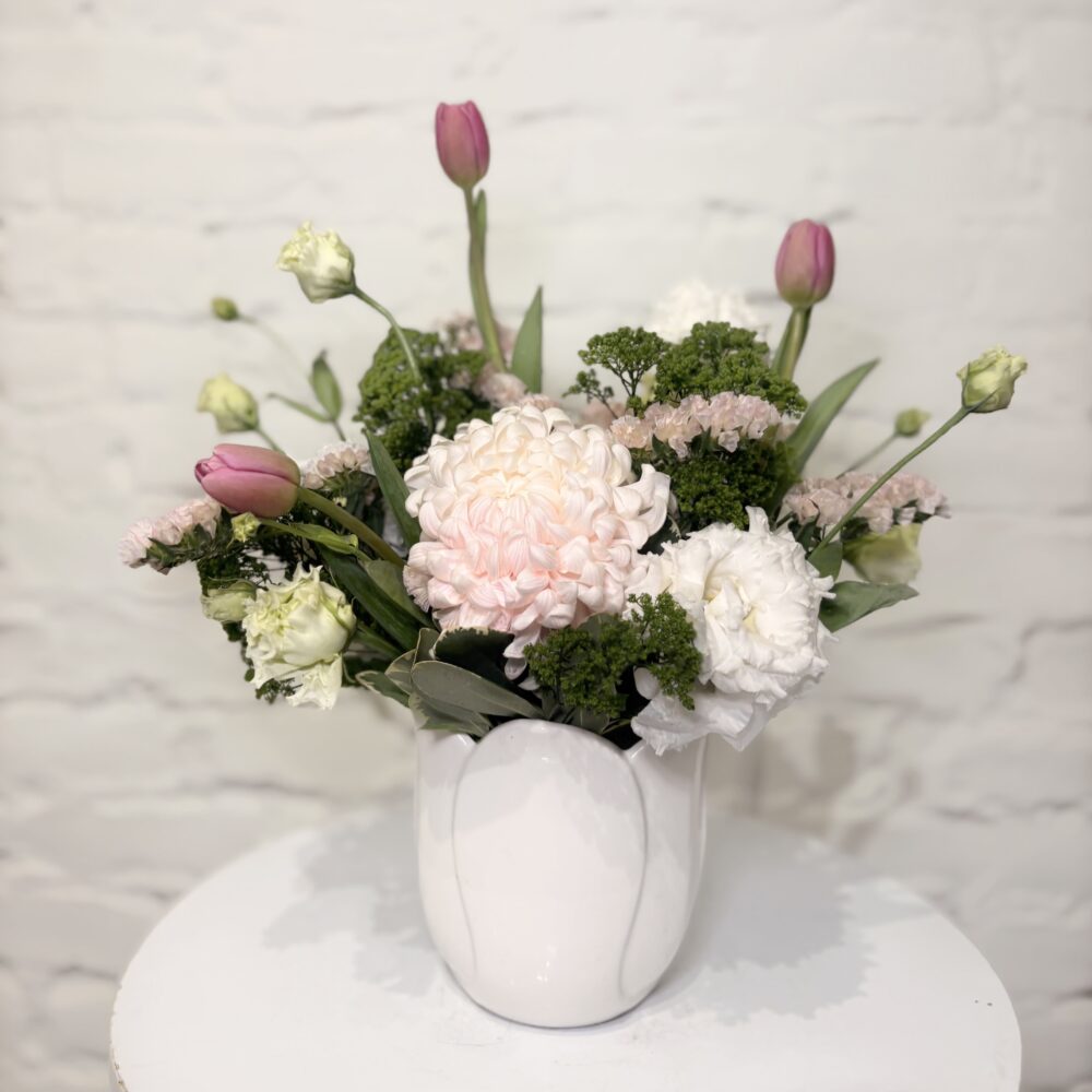 Blush and Blooms pastel spring flower arrangement with chrysanthemum, tulips, lisianthus and trachelium in a white ceramic vase