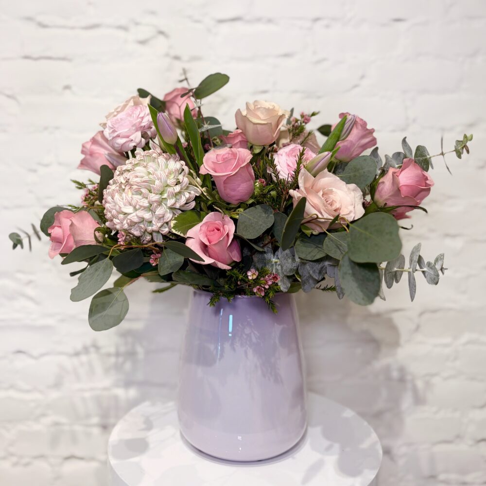 Pink Mother’s Day flower arrangement with roses, ranunculus, tulips and mum in ceramic vase