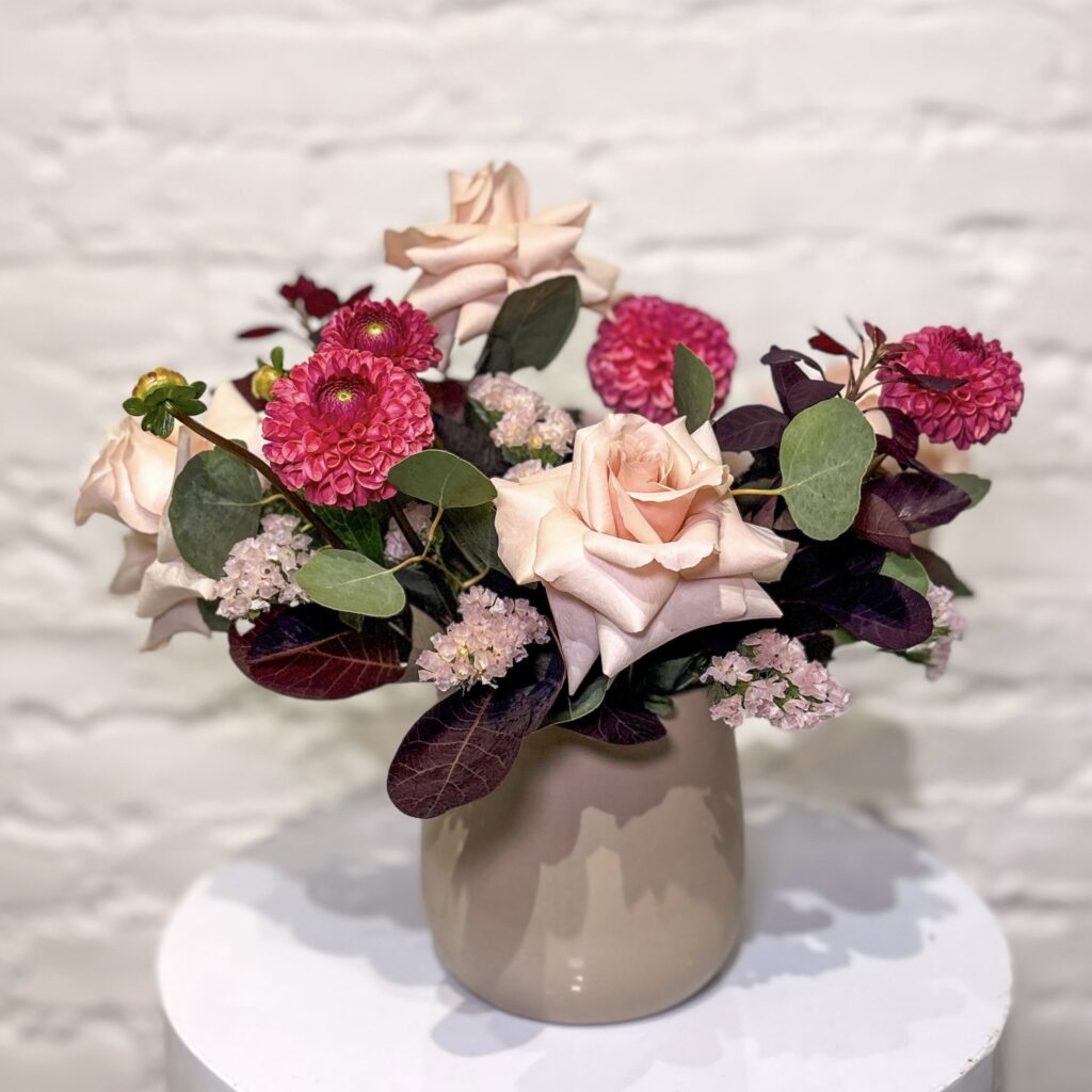 Burgundy Beauty flower arrangement with blush roses, pink dahlias, statice, smokebush and fresh greens