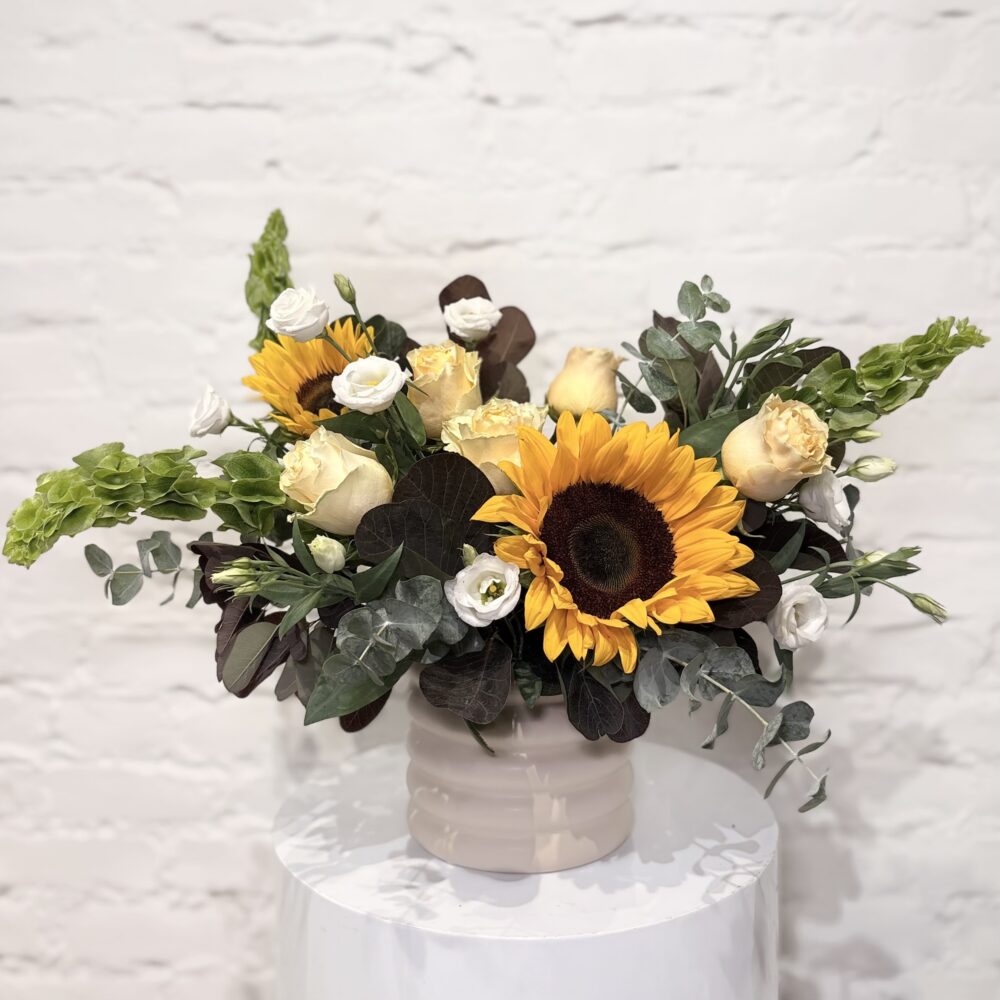 Homegrown flower arrangement with sunflowers, roses, lisianthus, Belles of Ireland, smokebush and fresh greens